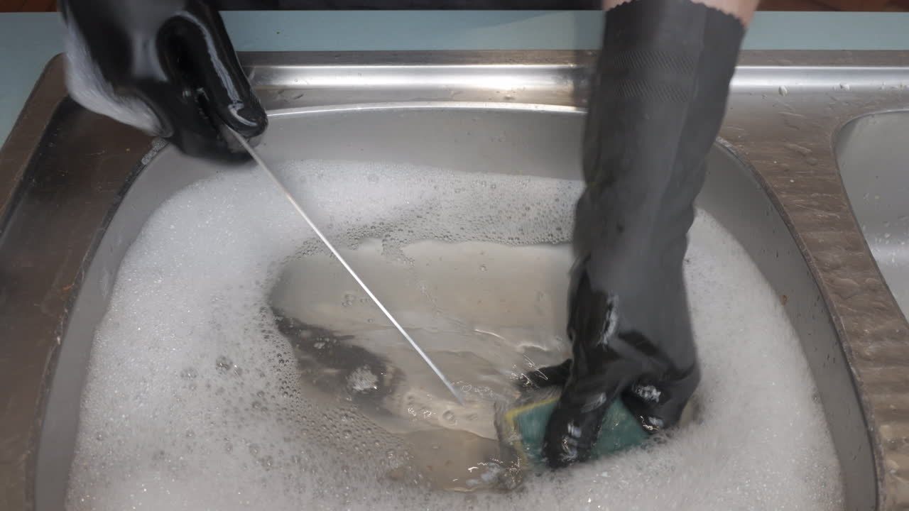 남성이 싱크대에서 큰 강철 칼을 씻는 동안