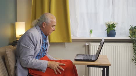 el viejo tiene frío y trata de usar una computadora portátil.