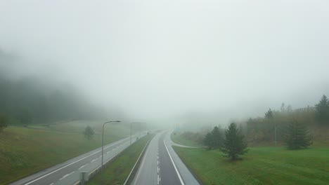cars pass through misty e18 highway in norway's foggy landscape