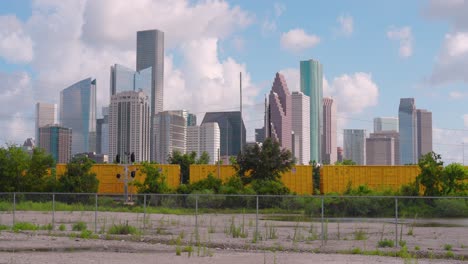 establishing shot of downtown houston, texas on cloudy but sunny day as train passes by