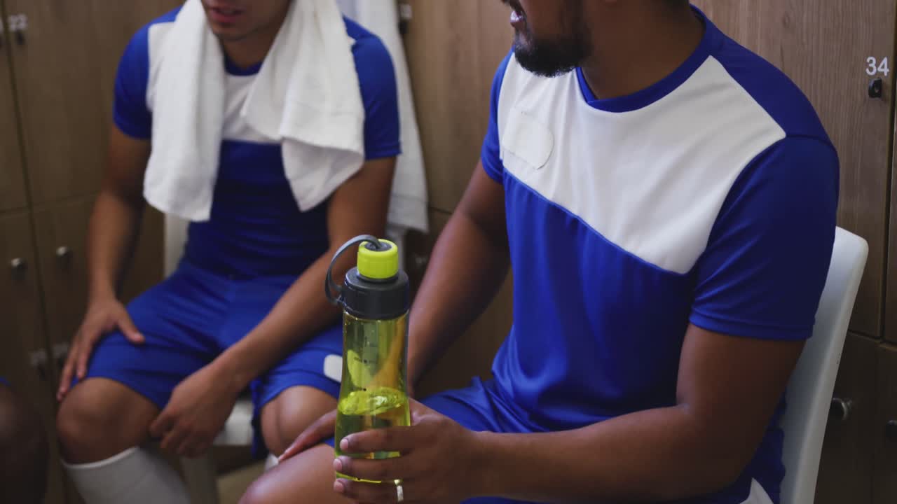 jugador de fútbol bebiendo agua en el vestuario