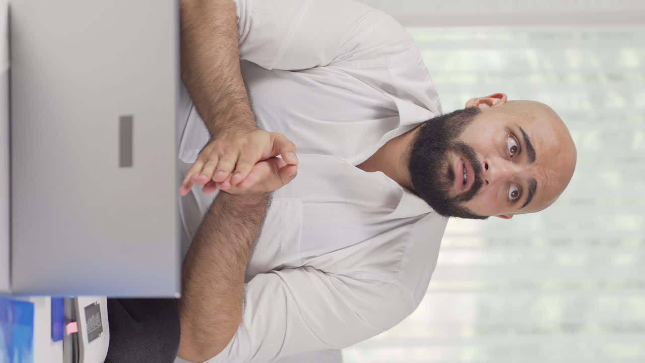 Video verticale: uomo che lavora da casa depresso