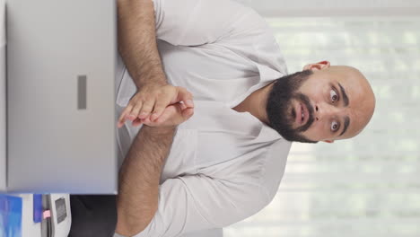 Vertical-video-of-Home-office-worker-man-getting-depressed.