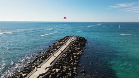 a popular tourist ocean seaway wall with pedestrian pathways and water activity