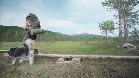 Mann-Mit-Großer-Campingtasche,-Begleitet-Von-Einem-Hundetrekking-Im-Nationalpark-Ånderdalen-Auf-Der-Insel-Senja,-Norwegen