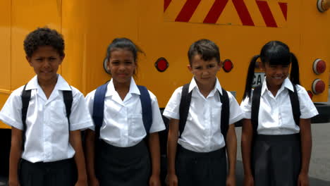 cute pupils showing thumbs up by bus