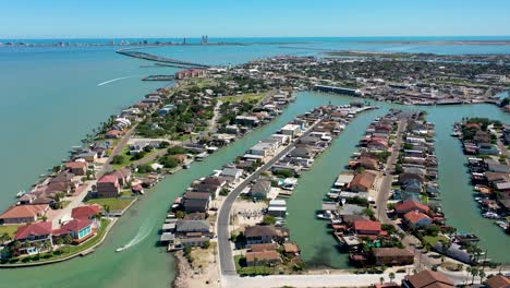 aerial video of port isabel, texas with a view of the laguna madre, the causeway and south padre island on the back, with two boats driving around on the video