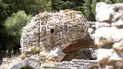 butrint, albania, view of the ruins of a building and stone walls with an arch