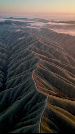 serpentine road through misty mountains