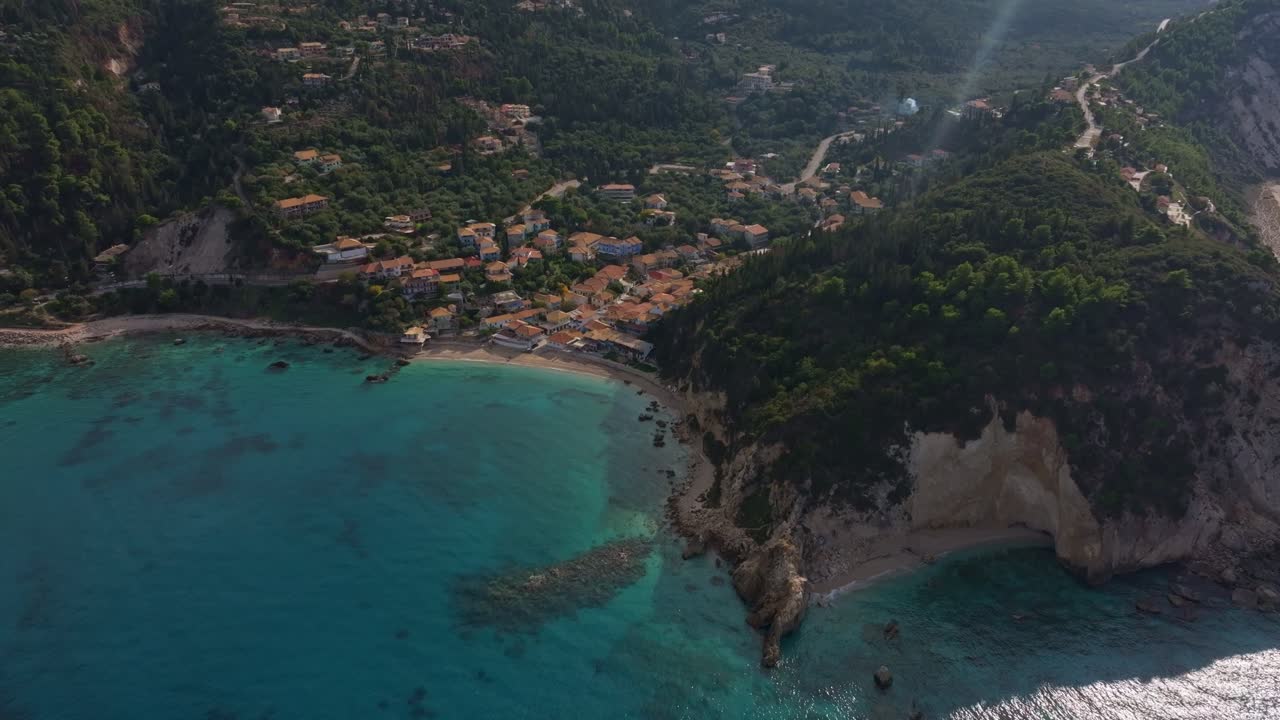 Yükselen dağlarla birleşen geleneksel deniz kenarı evleri, Lefkada, Yunanistan