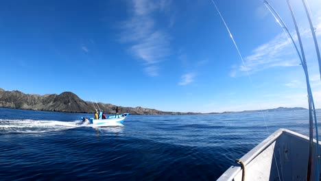 open ocean fishing boat traverses calm waters, bahia asuncion coastline in background