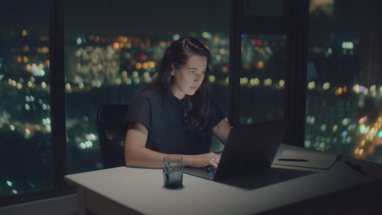 Mujer europea tecleando texto con la pantalla iluminada