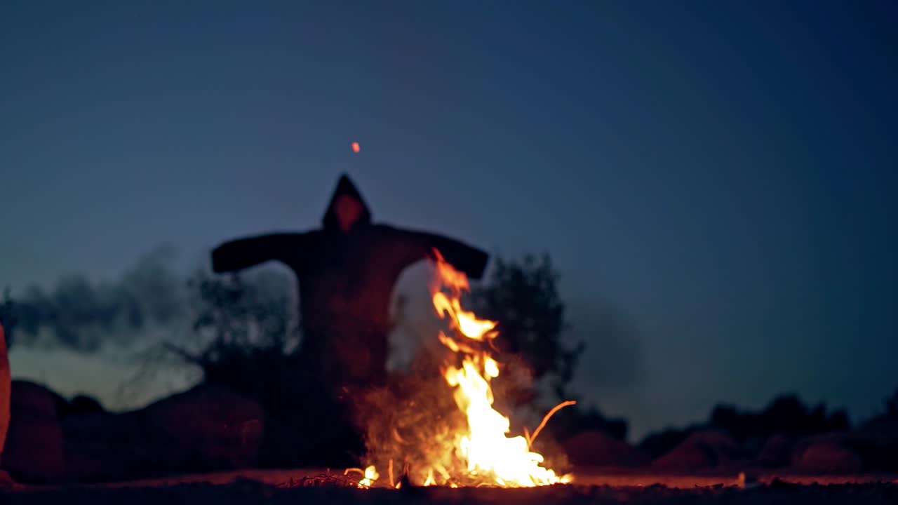 An old witch conjures on Halloween Day of the Dead. Burning fire. Bonfire.