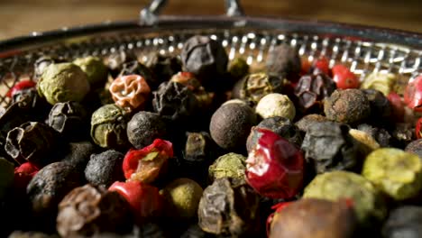 close-up of mixed peppercorns in a silver bowl