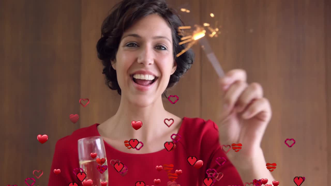 Mujer alzando una copa y agitando una bengala, generando una superposición de corazón rojo para marketing de fiestas.