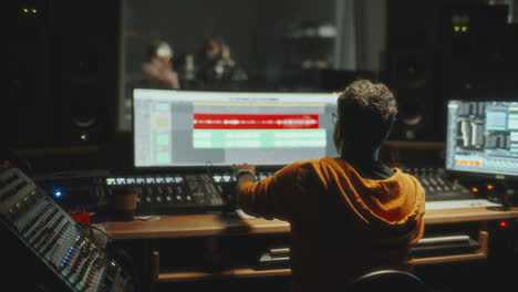 audio engineer mixing tracks in professional recording studio