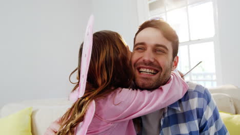 niña vestida con un disfraz de hadas abrazando a su padre