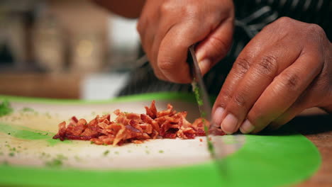 chopping fried bacon into bits to top off a delicious homemade recipe - slow motion