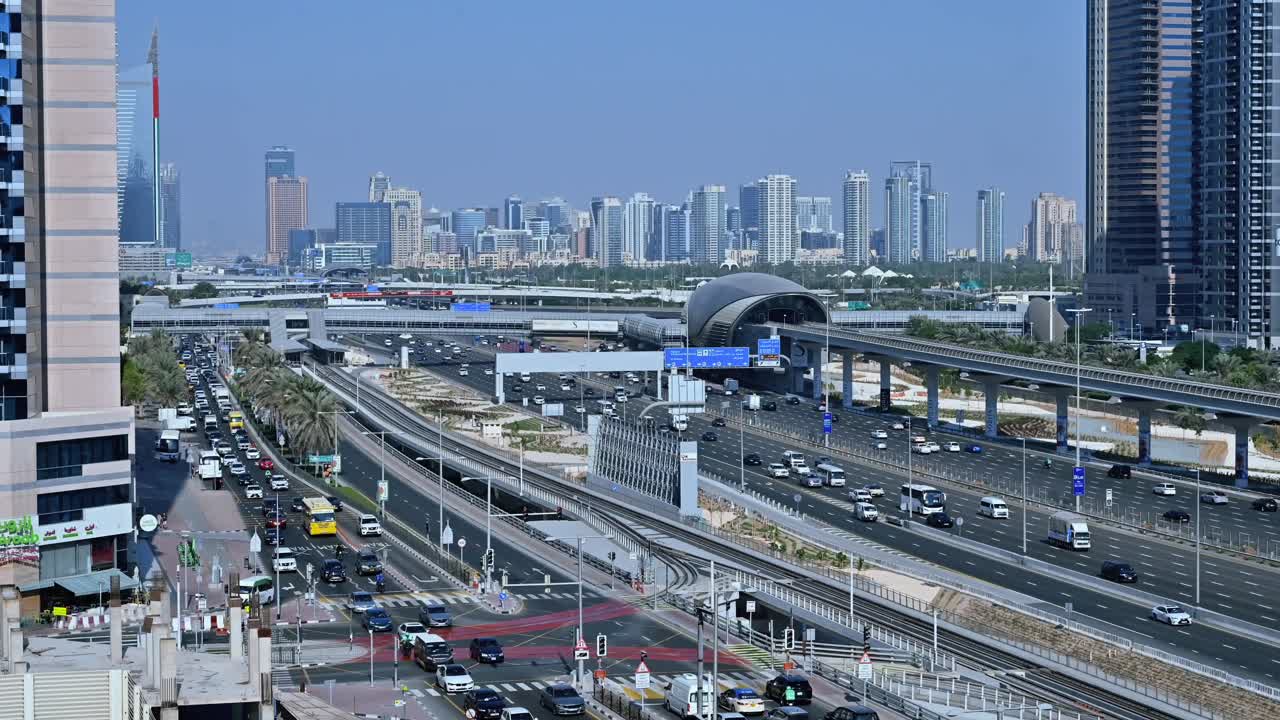 A Dubai Metro train departs the station, heading to its next stop along Sheikh Zayed Road amidst the traffic flow in Dubai, UAE