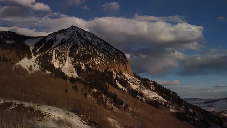 last rays of light touching mountain in colorado during sunset, dolly aerial