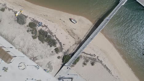 A-group-of-tourists-stroll-along-the-deserted-beach-of-Faro,-enjoying-the-tranquility-and-beauty-of-the-shoreline-together