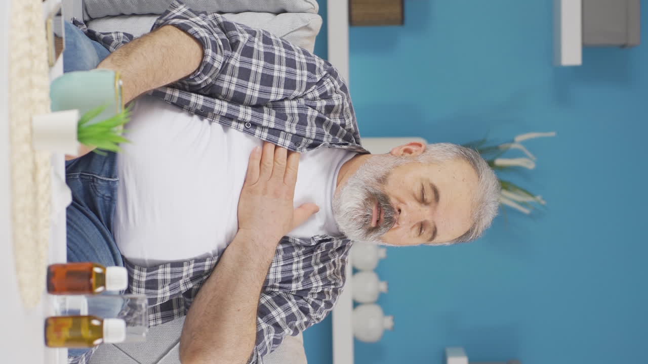 Vertical video of The sick old man can't stop coughing.