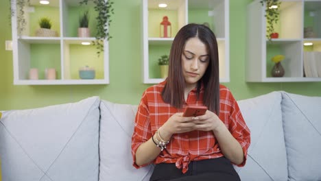 Young-woman-texting-on-the-phone-is-unhappy-and-sad.