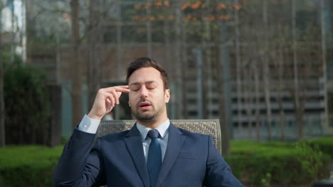 stressed young man takes off glasses suffering from muscles tension, having painful head feelings due overwork or sedentary working lifestyle