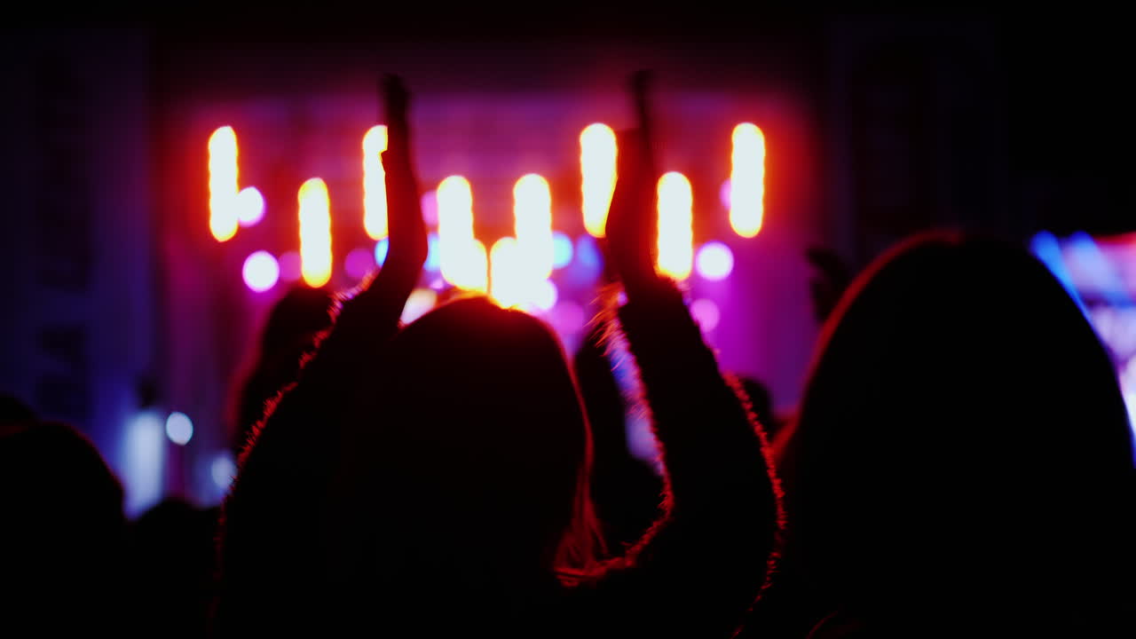Spettatori battono le mani, tenendo le mani sopra la testa. Fan ad un concerto rock all'aperto.