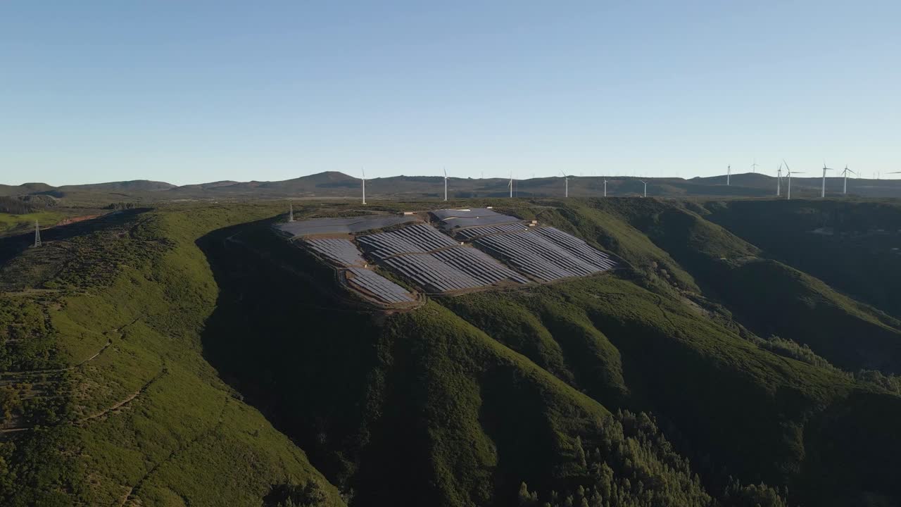 Aerial view of a photovoltaic farm and a wind farm on top of a mountain in Paul da Serra Madeira island