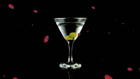 Animation-of-balls-with-samoa-flags-falling-over-glass-of-martini-on-black-background