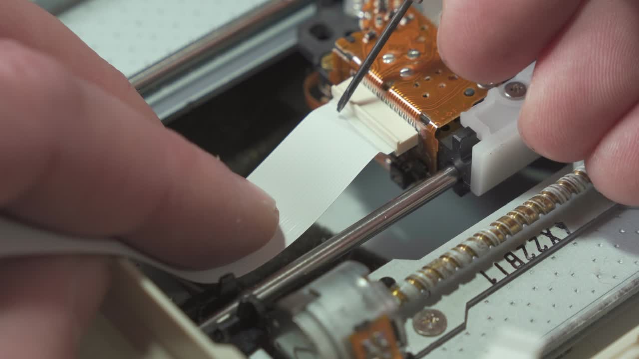 전자기기 수리공의 작업: 디지털 카드에서 루프 케이블을 분리합니다.