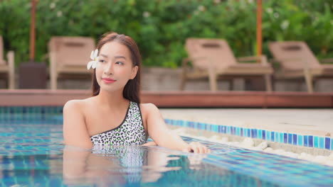 Hermosa-Joven-Modelo-Asiática-En-Traje-De-Baño-Y-Flor-De-Pelo-En-La-Piscina-De-Un-Hotel-Tropical-De-Lujo