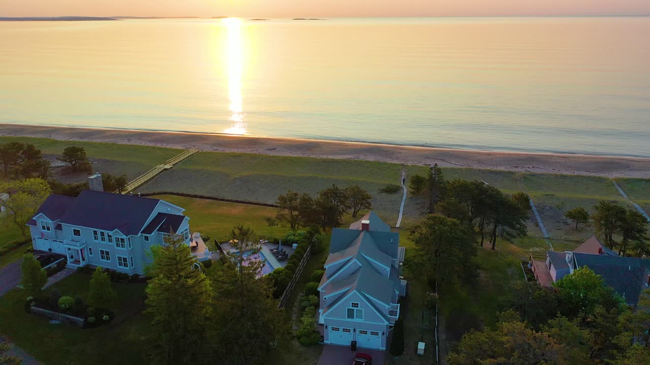 해가 뜨고 해변에 있는 집들, 바다의 파도에서 반사되는 색, 그리고 뉴잉글랜드 대서양 연안에 있는 휴양주택들.