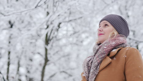 low angle shot of middle-aged woman admires winter forest 4k video