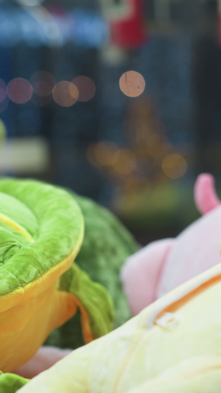 활기찬 플러시 장난감의 클로즈업, 노란색과 초록색으로 장난감을 장식한 아케이드 클로 머신, 배경에 흐릿한 다채로운 불빛과 미묘한 반사