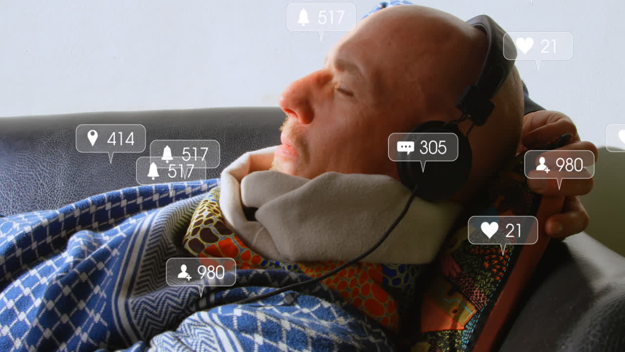 소셜 미디어 아이콘의 애니메이션에서 백인 노인이 집에서 소파에 누워서 음악을 듣고 있습니다.