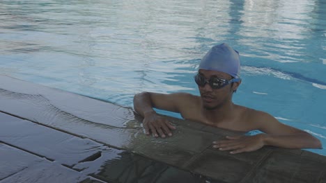 young swimmer wearing goggles, gliding, diving and swimming in the pool