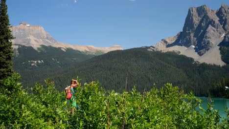 Vista-Lateral-De-Una-Joven-Excursionista-Caucásica-Haciendo-Clic-En-Selfie-Con-Un-Teléfono-Inteligente-Cerca-De-La-Orilla-Del-Río-4k