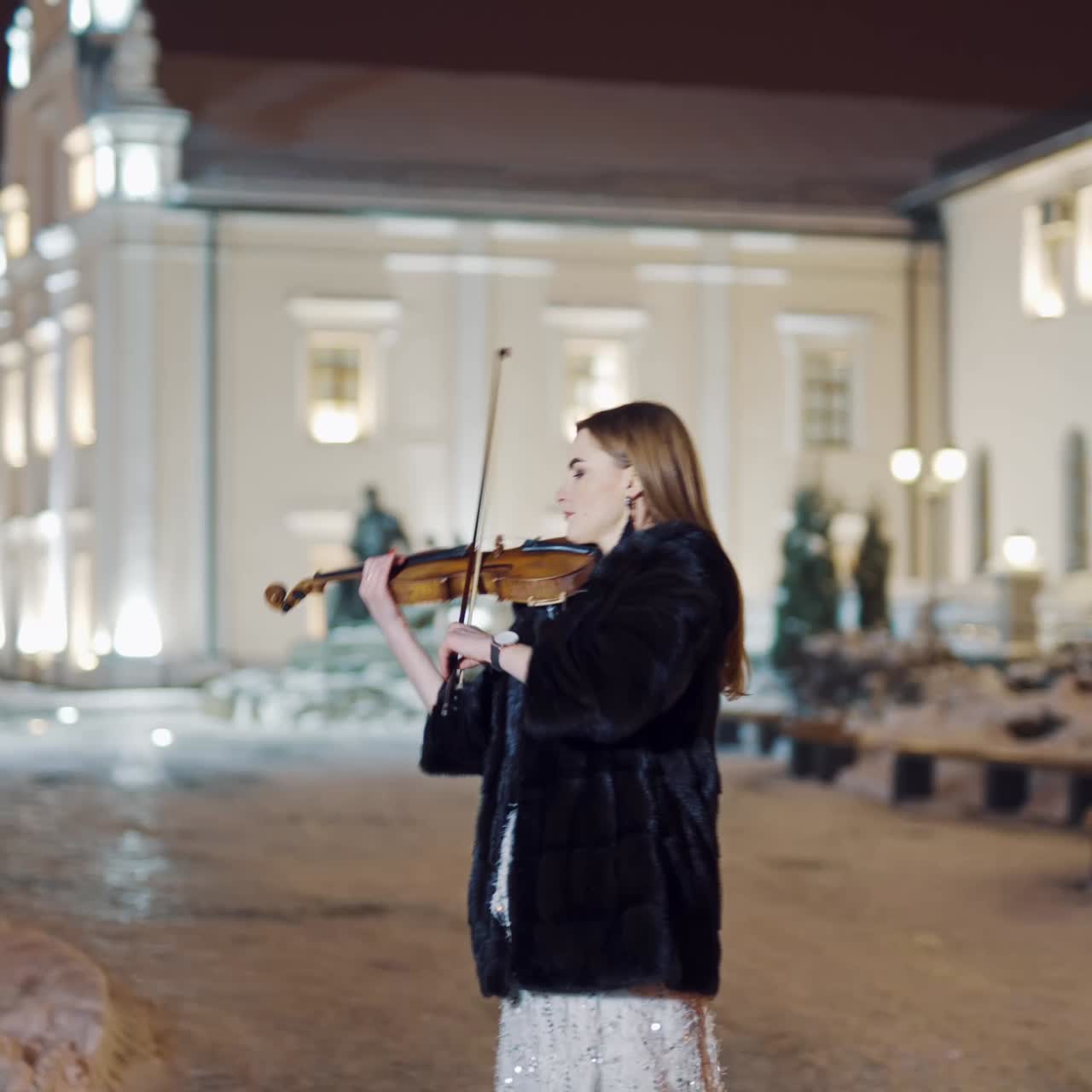 Woman playing on violin at nigh