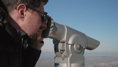 hombre mirando a través de un telescopio
