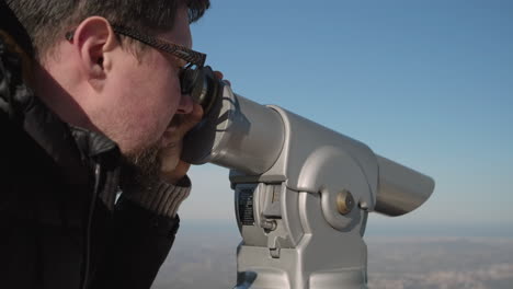 man looking through a telescope