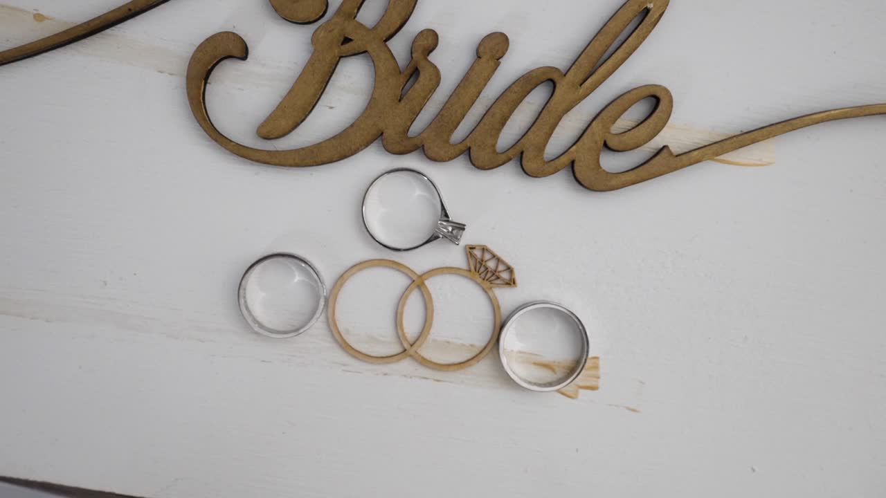 소박한 목조 신부 표지판에 놓인 결혼 반지