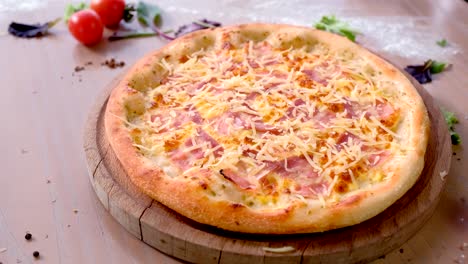pizza con tocino y queso en una tabla de madera en la mesa.
