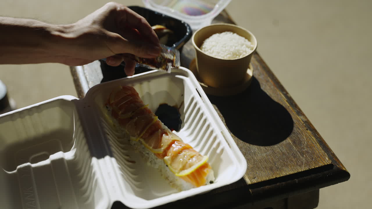 verter salsa de soja en sushi plato principal rollo arroz anguila sashimi palillos 4k