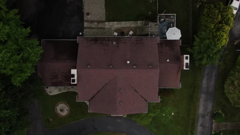 aerial top down drone footage rising up over a large house in a luxury neighborhood