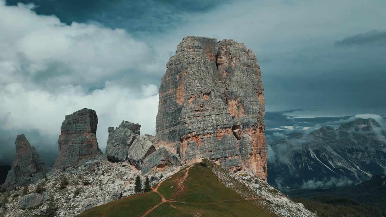 Dramatic cloudscape drifting over rugged Cinque Torri peaks, revealing stunning geological formations in Dolomites mountain landscape