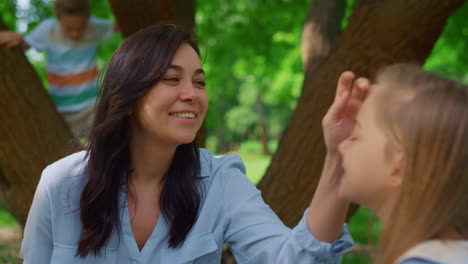 una madre sonriente acaricia a su hija en un picnic de cerca. los niños se divierten con la madre.