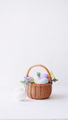 easter basket with pastel eggs and flowers