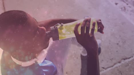 Animation-of-glowing-lights-over-an-exercising-african-american-man-drinking-water